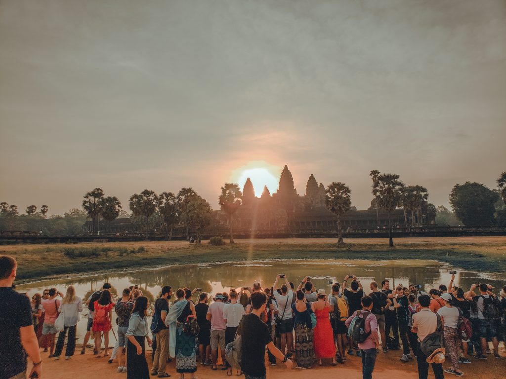 tour groups at sunrise over Angkor Wat